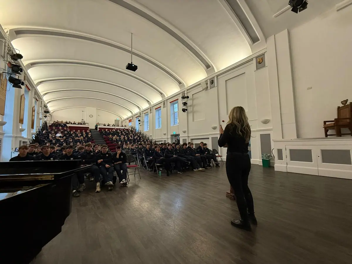 Klaudia delivering Deaf Awareness training to a large school audience in a hall